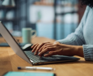 Close Up on Hands of a Female Specialist Working on Laptop Compu
