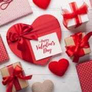 Top-down view of Valentine’s Day gift boxes in red and white with a card that reads "Happy Valentine's Day."