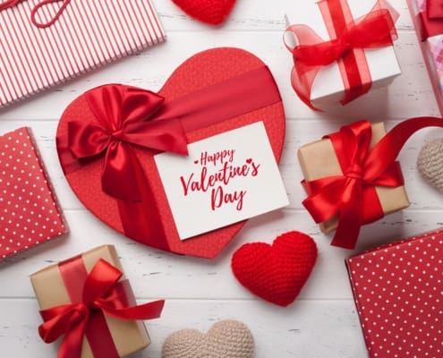 Top-down view of Valentine’s Day gift boxes in red and white with a card that reads "Happy Valentine's Day."